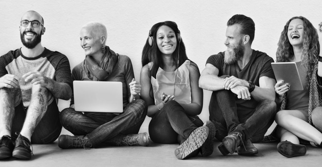 A group of diverse people is using digital devices