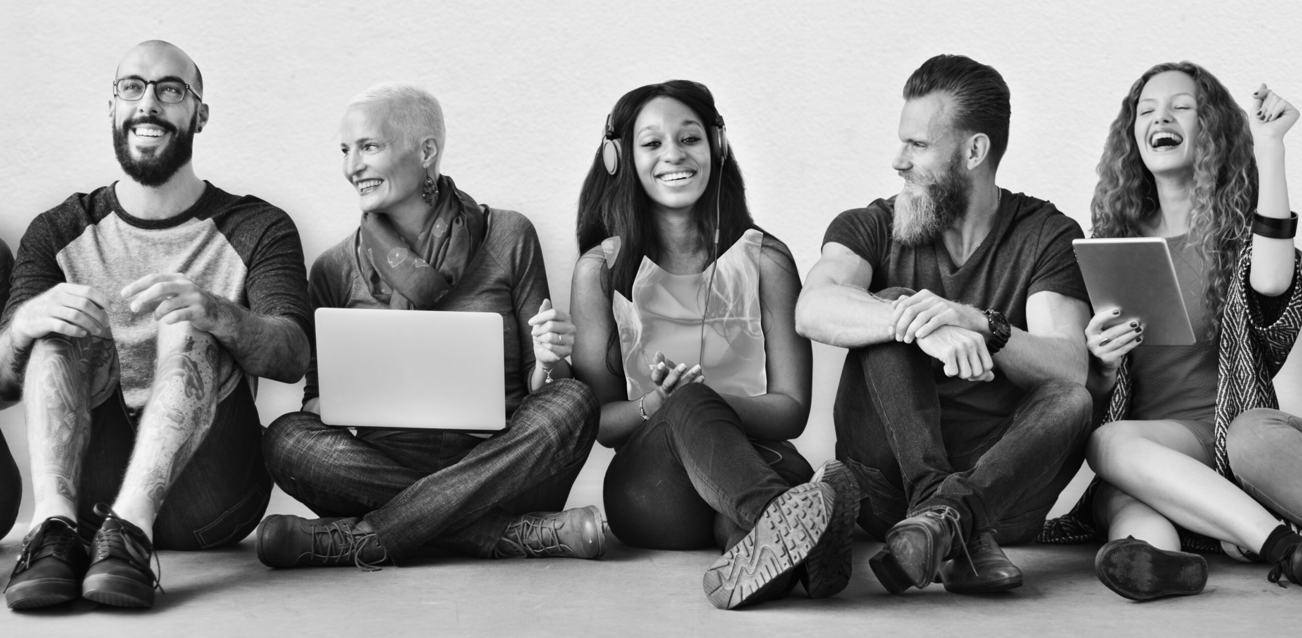 A group of diverse people is using digital devices